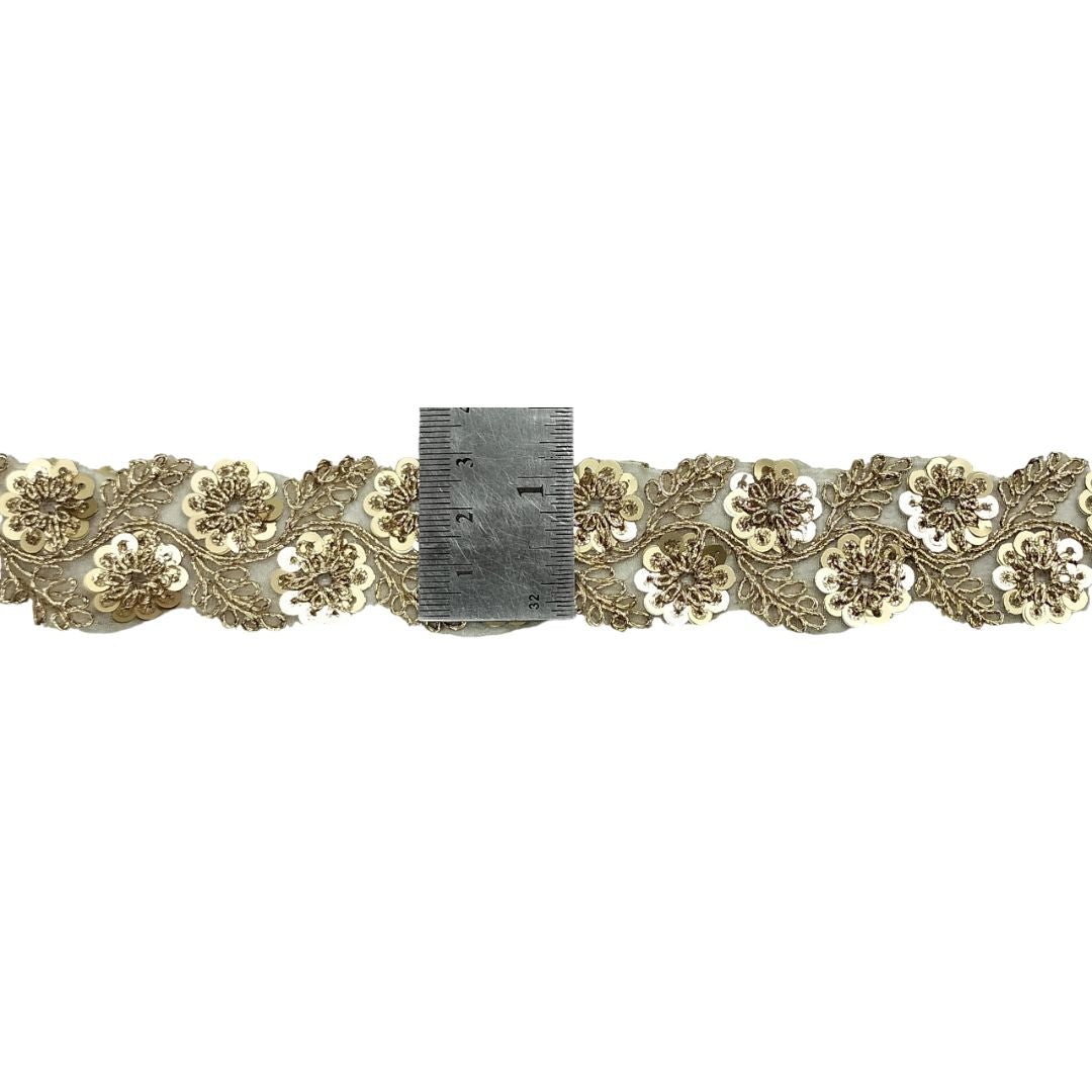 Decorative floral lace trim with a ruler for scale on a white background